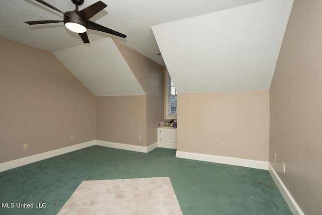bonus room with a ceiling fan, dark carpet, vaulted ceiling, baseboards, and a textured ceiling