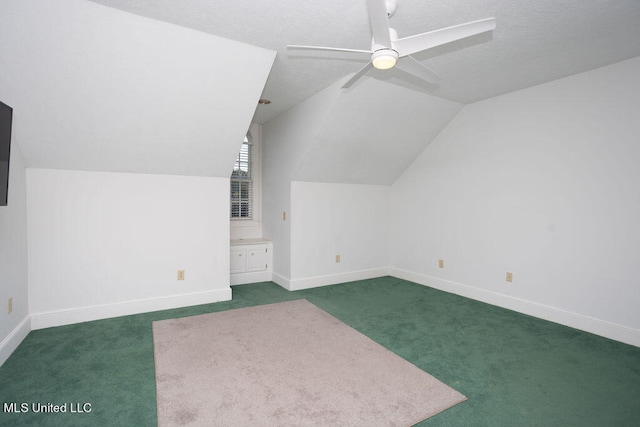 bonus room with ceiling fan, a textured ceiling, vaulted ceiling, and dark colored carpet