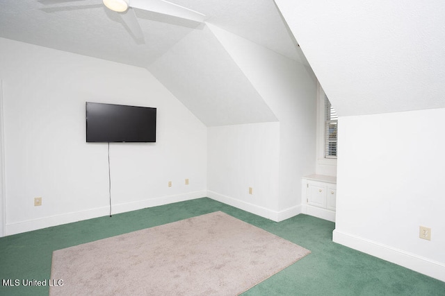 additional living space with ceiling fan, vaulted ceiling, and dark carpet