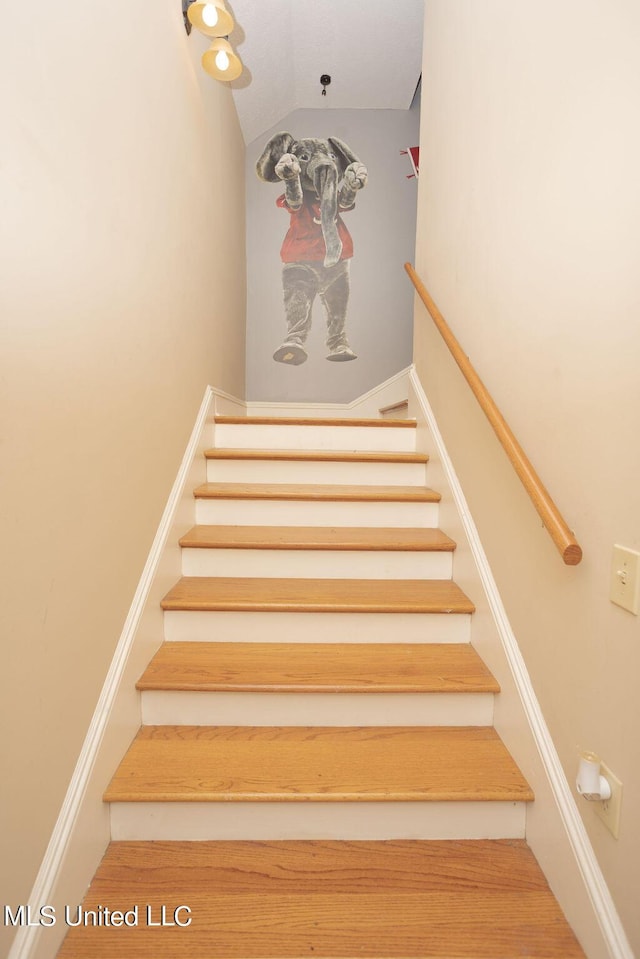 staircase featuring lofted ceiling