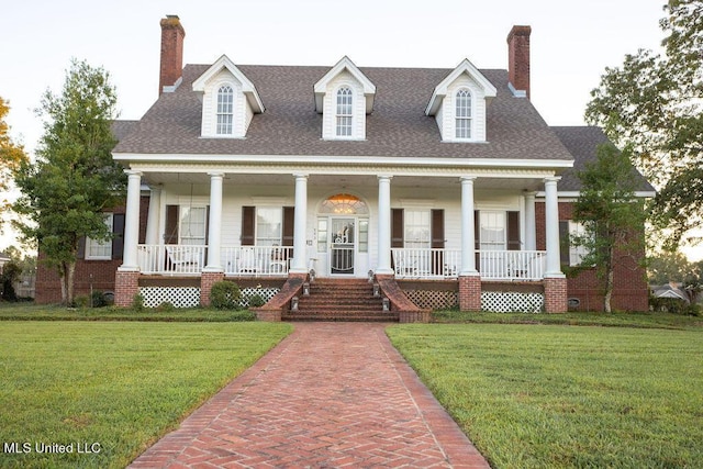 view of front of home with a chimney, a porch, and a front yard