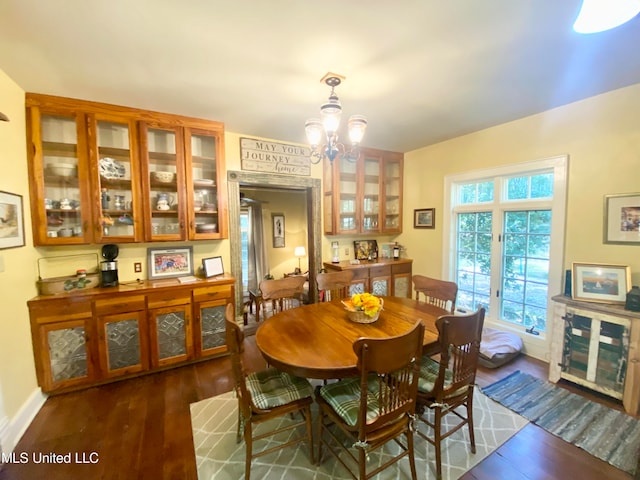 dining area featuring a notable chandelier and dark hardwood / wood-style flooring