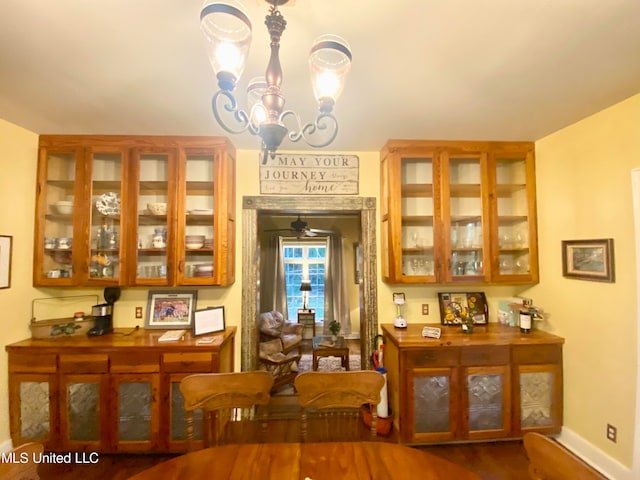 dining room with dark hardwood / wood-style floors and ceiling fan with notable chandelier