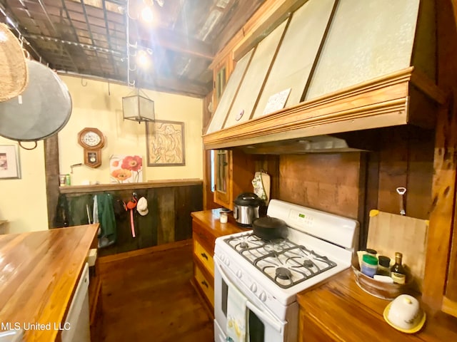 kitchen with custom exhaust hood, wood counters, white gas stove, and wooden walls