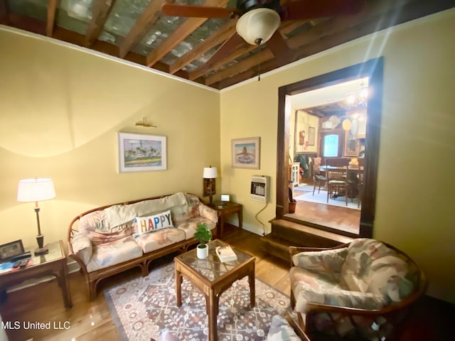 living room with ceiling fan, hardwood / wood-style flooring, beamed ceiling, and heating unit