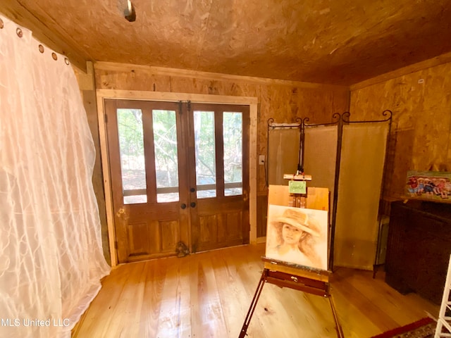 entryway featuring french doors, wood walls, and wood-type flooring