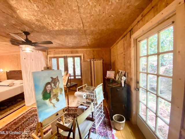 interior space with french doors, ceiling fan, a wealth of natural light, and hardwood / wood-style floors