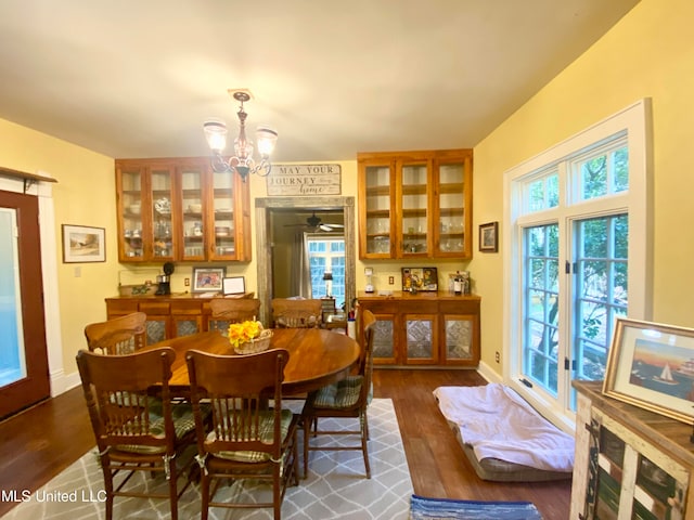 dining space featuring a wealth of natural light, a chandelier, and dark hardwood / wood-style flooring