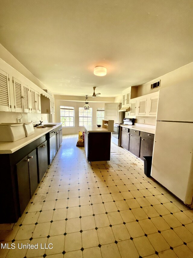 1903 Circle Dr, Picayune, MS 39466 - kitchen with electric range, visible vents, freestanding refrigerator, dishwashing machine, and a kitchen island