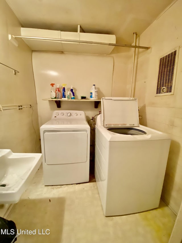 1903 Circle Dr, Picayune, MS 39466 - laundry area with light floors, laundry area, visible vents, a sink, and washing machine and clothes dryer