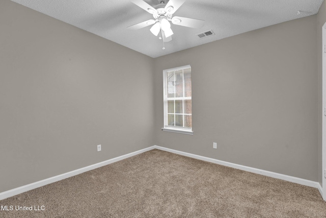 carpeted spare room with a textured ceiling and ceiling fan