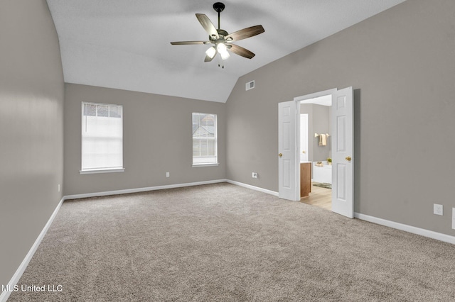 unfurnished bedroom with ceiling fan, light colored carpet, and vaulted ceiling