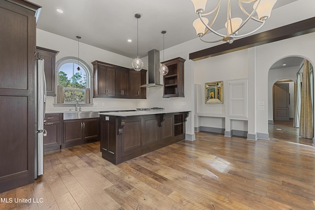 31 Poplar Cir, Gulfport, MS 39507 - kitchen with wall chimney exhaust hood, light countertops, dark brown cabinets, open shelves, and arched walkways