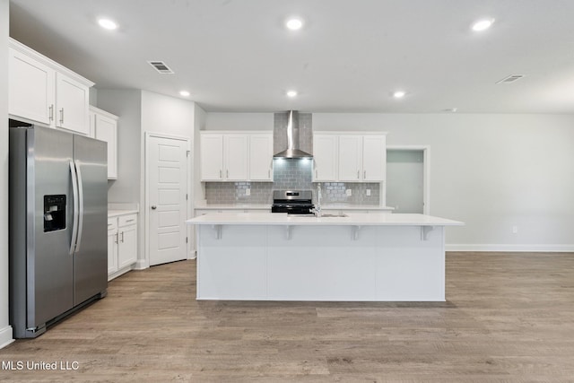 5006 Sand Dollar Dr, Long Beach, MS 39560 - kitchen featuring stainless steel appliances, wall chimney range hood, light countertops, an island with sink, and decorative backsplash