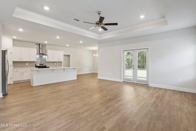 5006 Sand Dollar Dr, Long Beach, MS 39560 - unfurnished living room featuring a raised ceiling, ornamental molding, light wood-type flooring, a ceiling fan, and recessed lighting