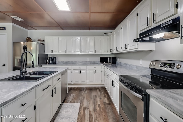 kitchen featuring hardwood / wood-style floors, sink, crown molding, white cabinetry, and appliances with stainless steel finishes