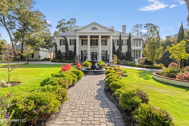 greek revival inspired property featuring a front lawn