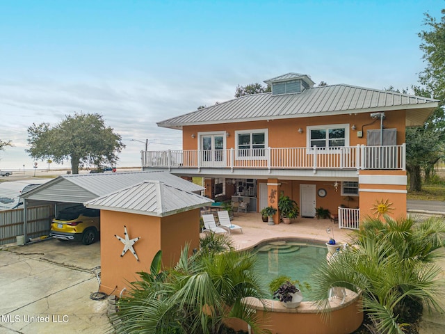 rear view of property featuring a patio area and a balcony