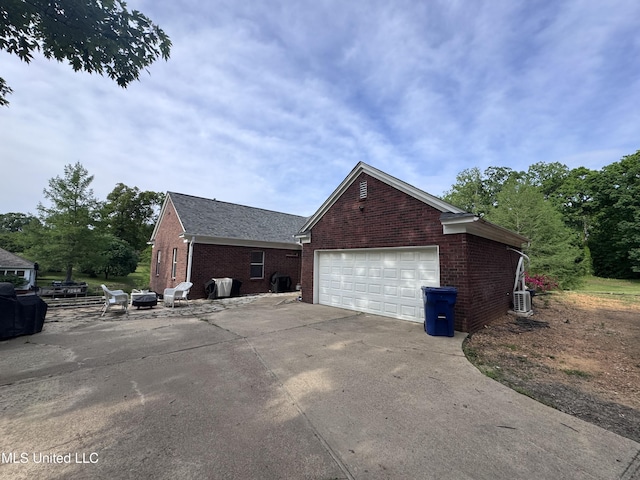 view of side of property featuring brick siding and a garage