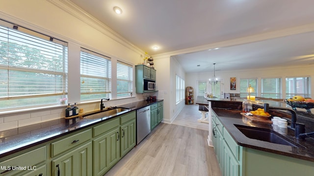 kitchen featuring crown molding, a sink, green cabinets, and stainless steel appliances