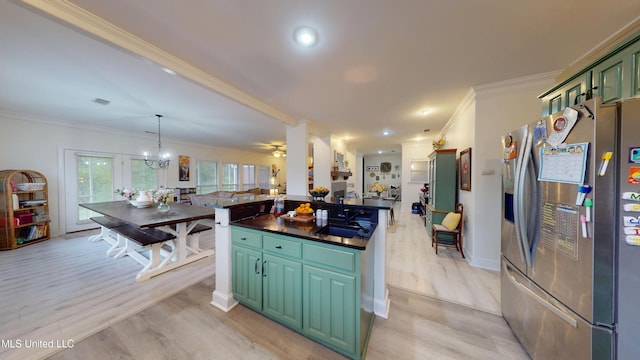 kitchen featuring a sink, open floor plan, light wood-type flooring, stainless steel refrigerator with ice dispenser, and ornamental molding