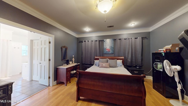 bedroom with visible vents, ornamental molding, light wood-style flooring, and baseboards