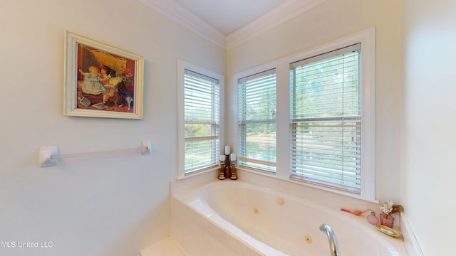 bathroom with a tub with jets, ornamental molding, and a wealth of natural light
