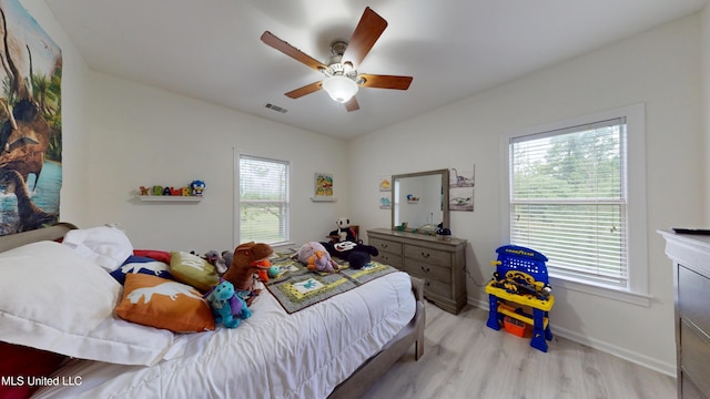 bedroom featuring ceiling fan, baseboards, visible vents, and wood finished floors