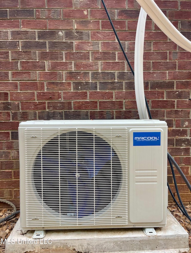 details featuring brick siding and ac unit