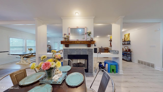 dining area with visible vents, baseboards, crown molding, and wood finished floors
