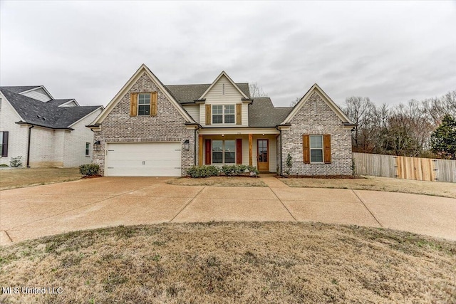 traditional-style house featuring brick siding, driveway, an attached garage, and fence