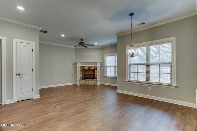 unfurnished living room featuring a brick fireplace, visible vents, baseboards, and wood finished floors