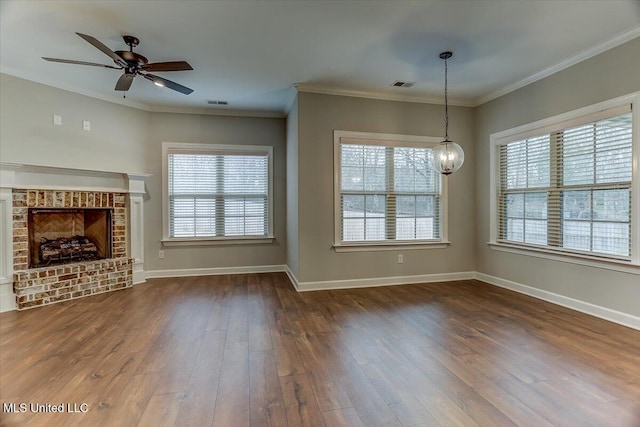 unfurnished living room with baseboards, a healthy amount of sunlight, dark wood finished floors, and crown molding