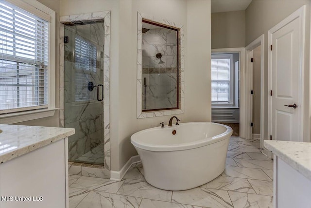 bathroom featuring marble finish floor, a soaking tub, a stall shower, vanity, and baseboards