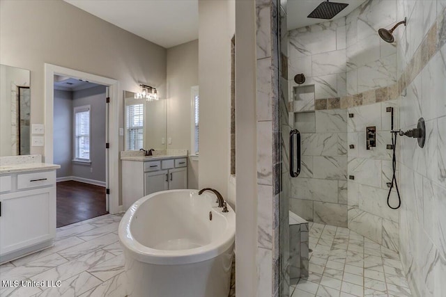 bathroom with marble finish floor, a shower stall, and a freestanding tub