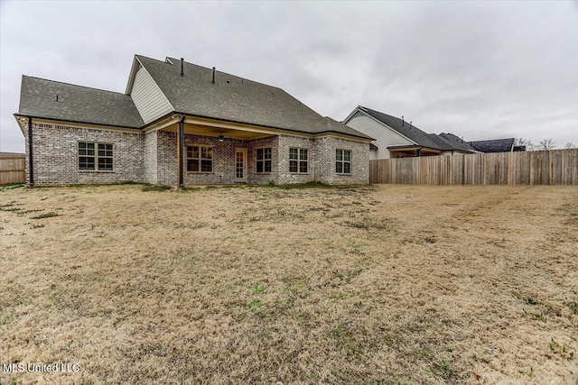 back of property featuring a fenced backyard and brick siding