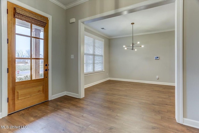 foyer with ornamental molding, baseboards, and wood finished floors