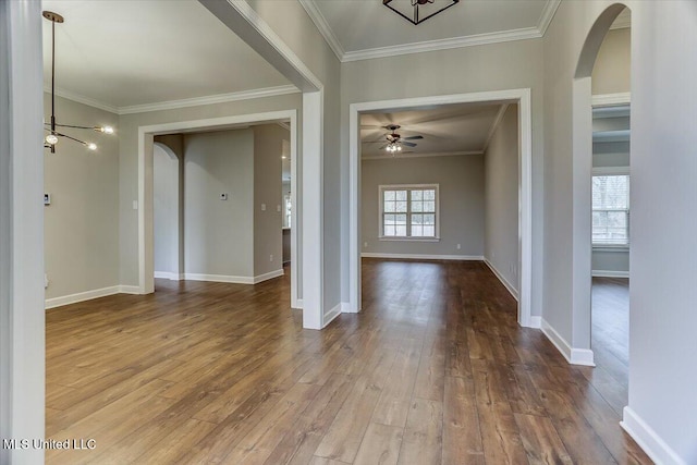 foyer with ornamental molding, arched walkways, baseboards, and hardwood / wood-style floors