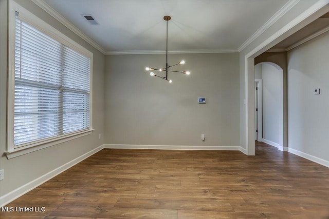 unfurnished dining area featuring arched walkways, a notable chandelier, wood finished floors, visible vents, and ornamental molding