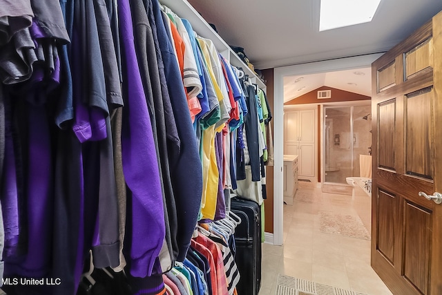 spacious closet with light tile patterned flooring and vaulted ceiling