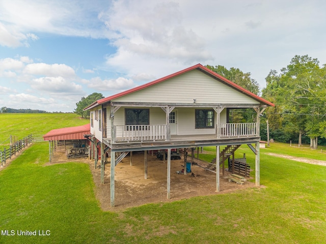 back of property with a yard and a porch