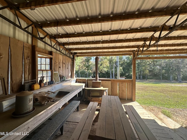 interior space with beam ceiling, wood-type flooring, and wood walls