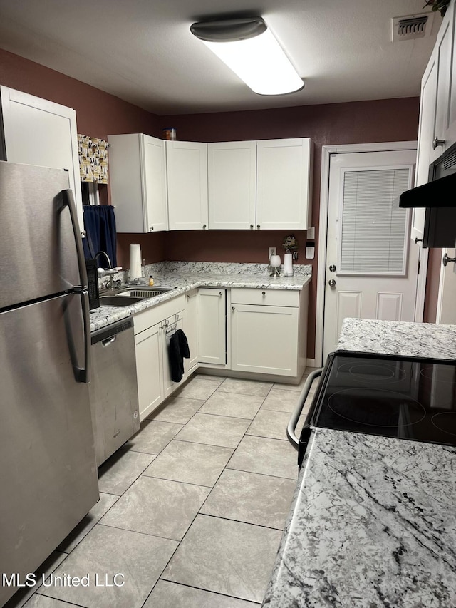 kitchen featuring visible vents, appliances with stainless steel finishes, light stone countertops, white cabinetry, and a sink