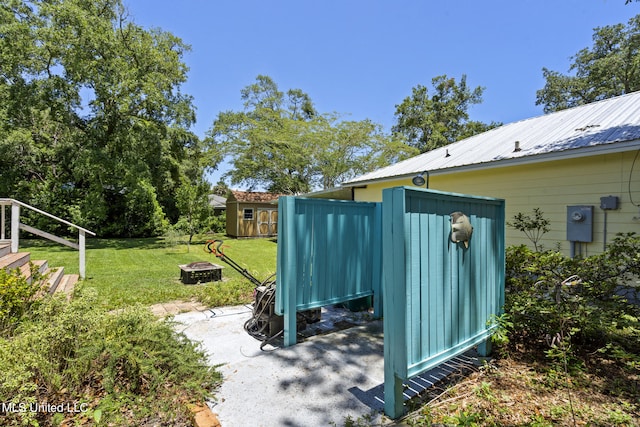 view of yard featuring an outdoor fire pit and a storage unit