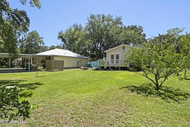 view of yard with a wooden deck and a carport