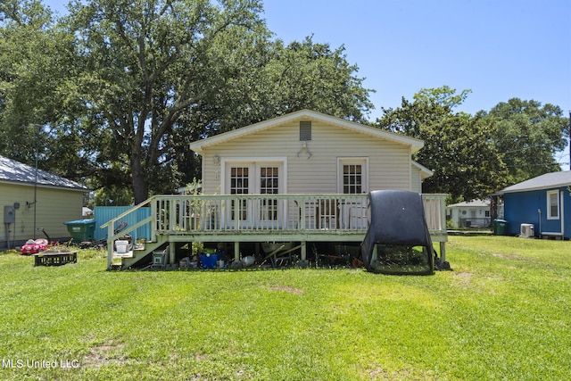 back of property featuring a wooden deck and a lawn