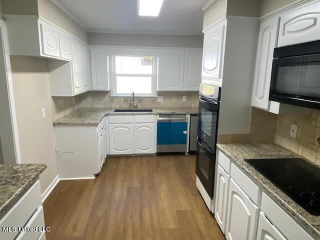 kitchen with white cabinetry, black appliances, dark wood-type flooring, and sink