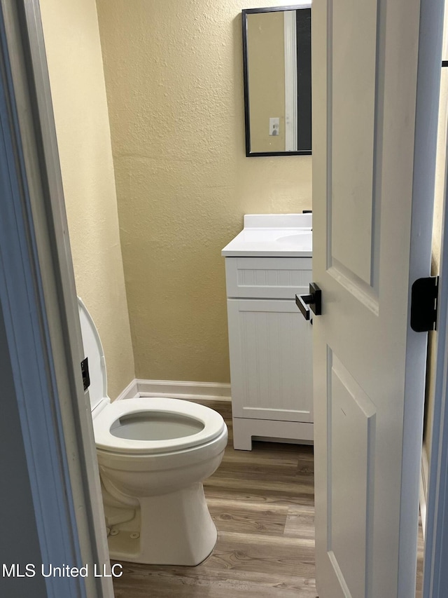 7701 Harold Ave, Moss Point, MS 39563 - half bathroom with wood finished floors, vanity, and a textured wall