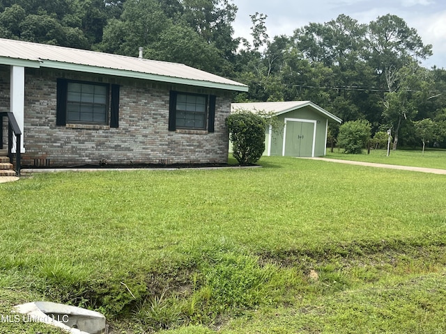 7701 Harold Ave, Moss Point, MS 39563 - view of property exterior featuring a yard, a storage shed, brick siding, and a metal roof