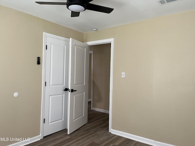 7701 Harold Ave, Moss Point, MS 39563 - unfurnished bedroom featuring dark wood-style flooring and ceiling fan